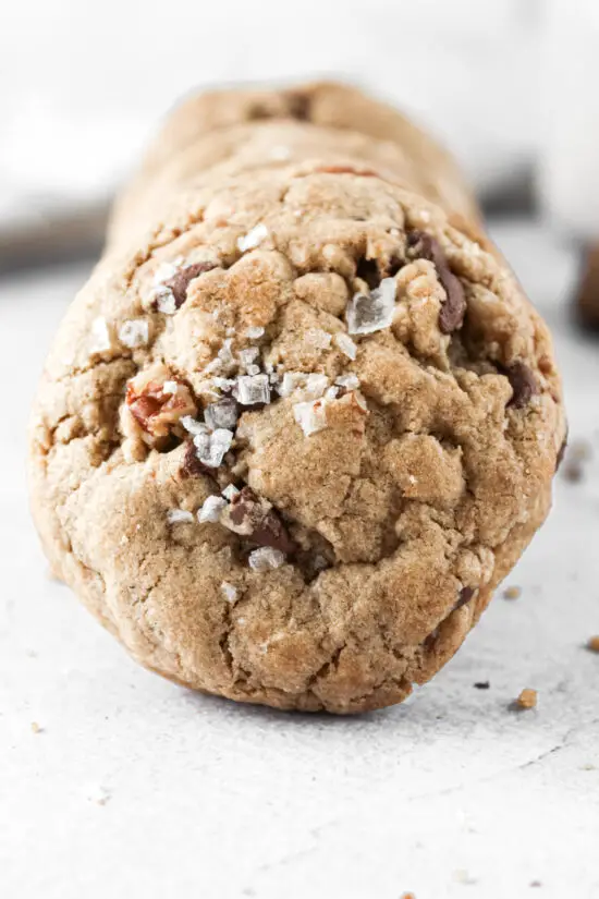 Large picture of a chocolate chip pecan cookie with flaky sea salt.