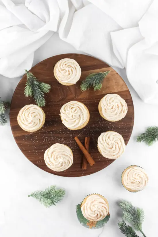 Eggnog Cupcakes with Eggnog Buttercream Frosting on round board. 