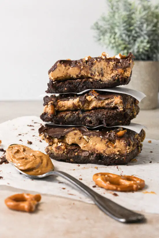Three stacked peanut butter pretzel brownies on top of each other.