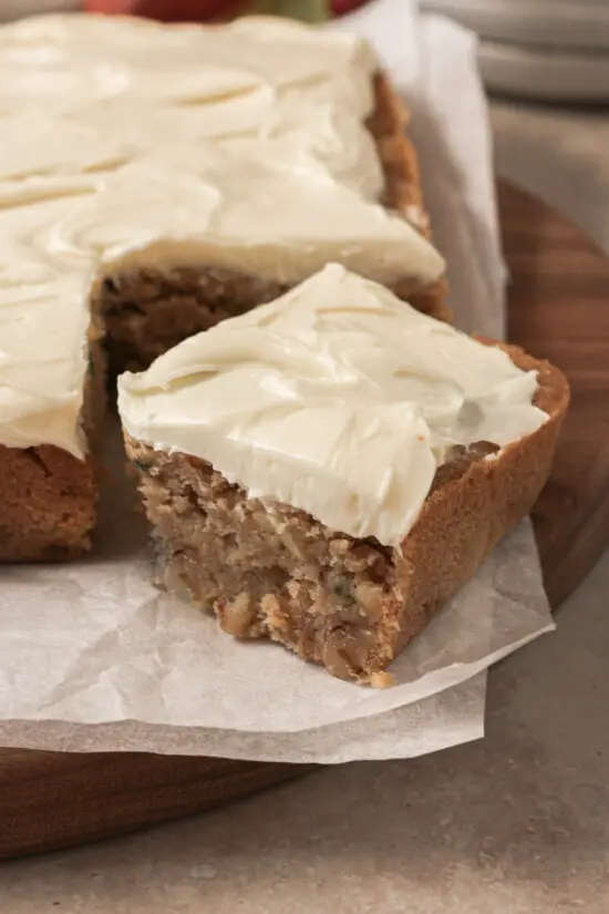 Large up close piece of Apple Harvest Snack Cake with cream cheese frosting on top.