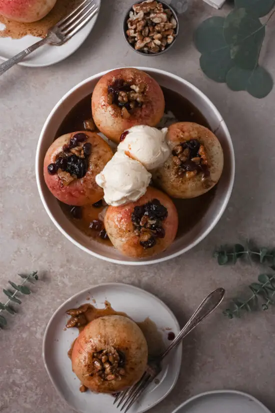 Four Baked Stuffed Apples with scoops of ice cream on top. 