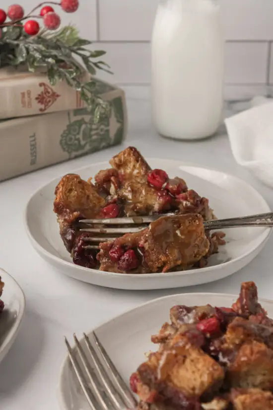 Up close picture of plate filled with holiday cranberry French toast bake and a fork in it.  