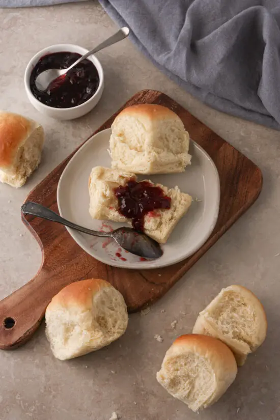 Buttermilk Dinner Rolls on a plate with berry jam spread on top.