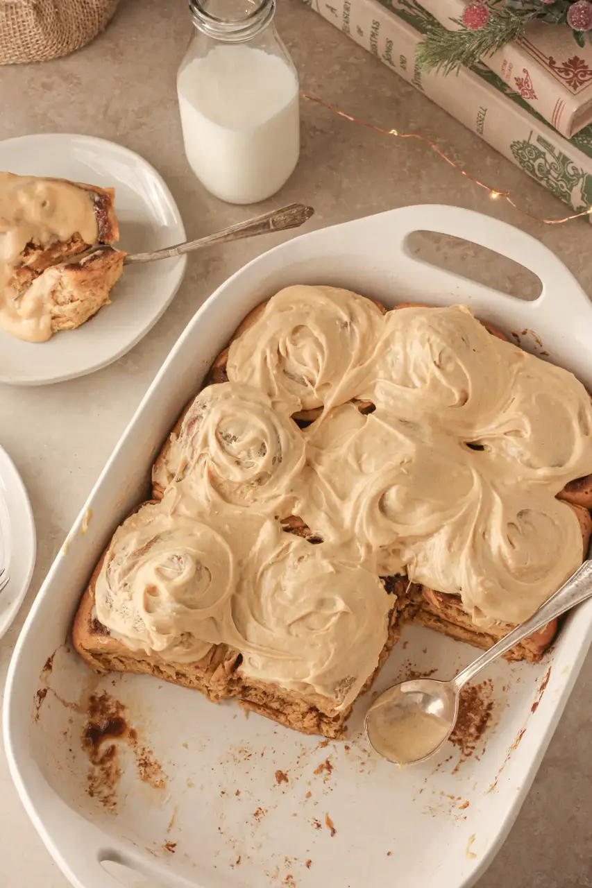 A white casserole dish with pan full of gingerbread cinnamon rolls.