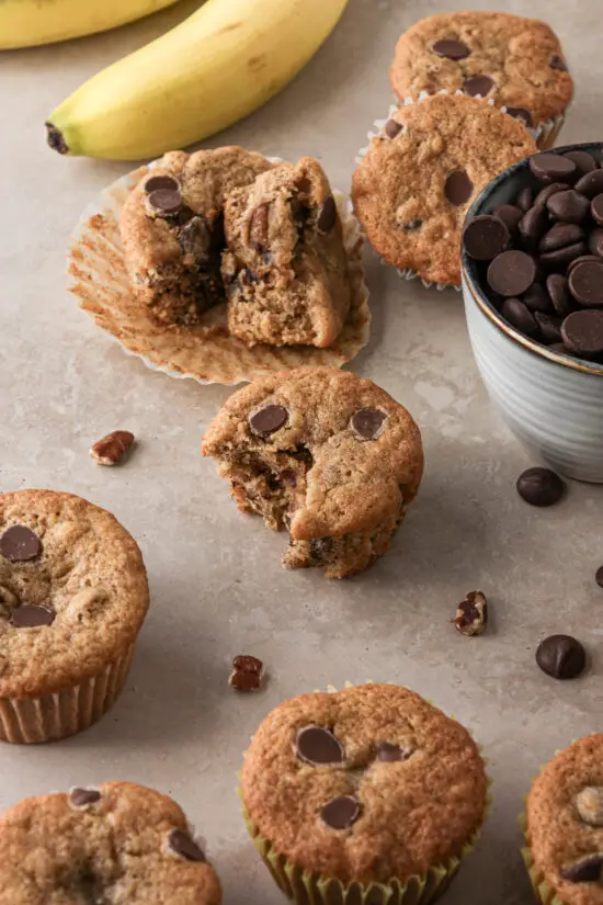 Banana Chocolate Chip Muffins, bowl of chocolate chips and bananas nearby. 