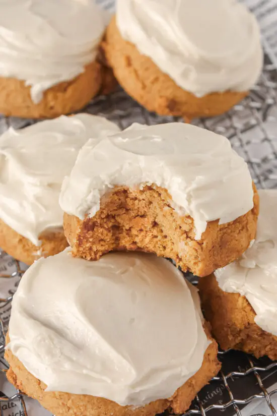 Bite taken out of a Soft Pumpkin Cookies with Cream Cheese Frosting.