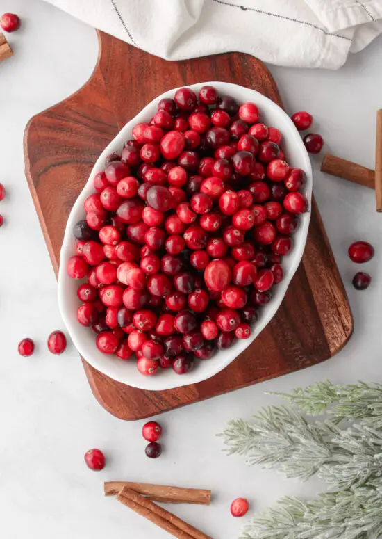 Fresh cranberries in a white bowl. 