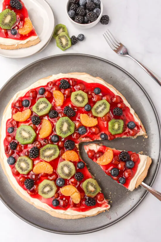 Pizza Pan filled with Fruit Pizza with slice taken out.